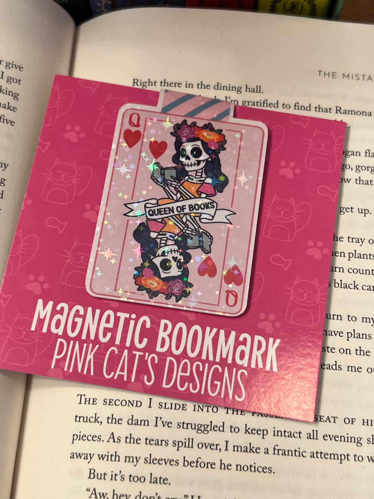 Pink magnetic bookmark with skull design on a book page