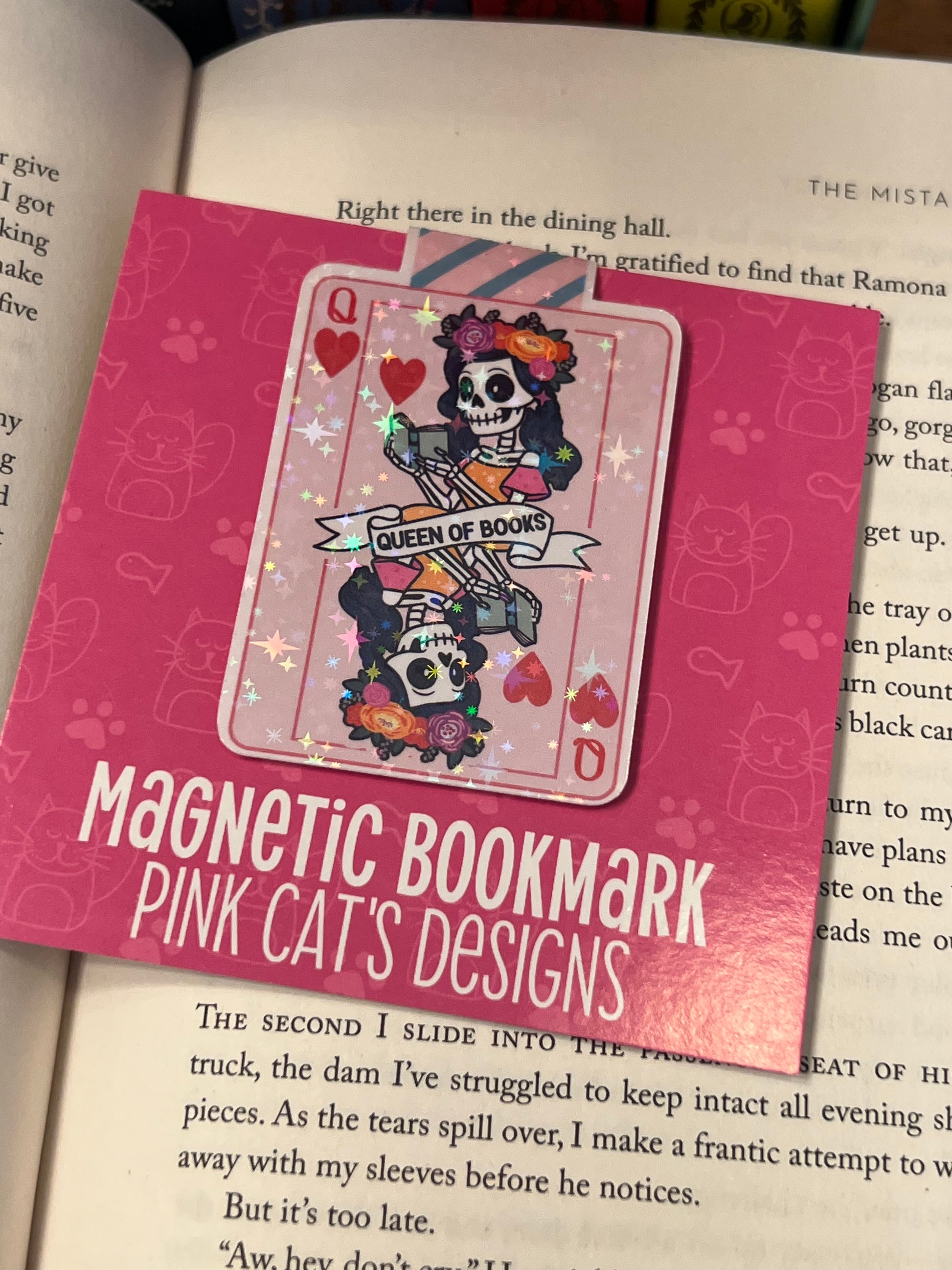 Pink magnetic bookmark with skull design on a book page