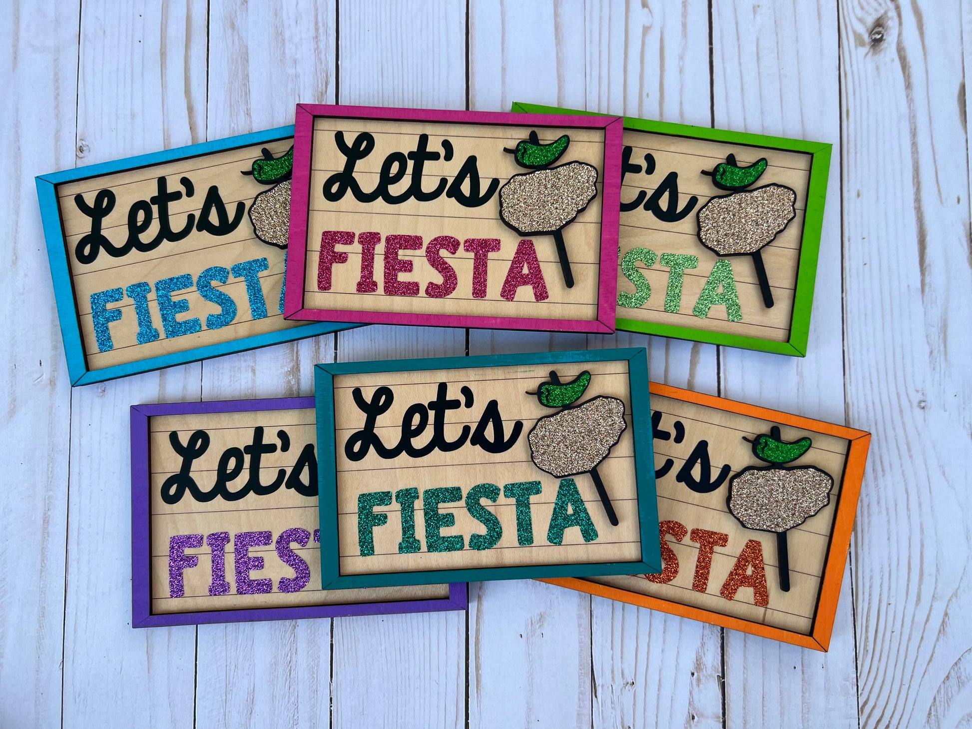 Colorful signs with 'Let's Fiesta' text with chicken on a stick graphic 
