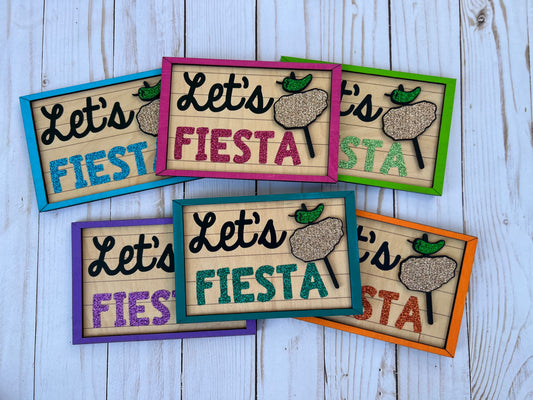 Colorful signs with 'Let's Fiesta' text with chicken on a stick graphic 